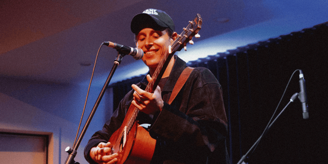 Ben Stewart smiling and playing guitar